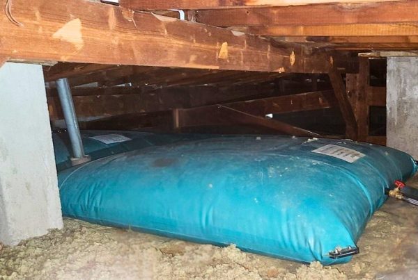 Mise en place de citernes souples remplies d’eau pour simuler les charges lors des essais de plancher.