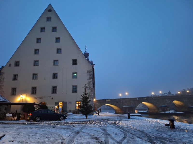 A heritage building in Regensburg, under the snow, near the old stone bridge