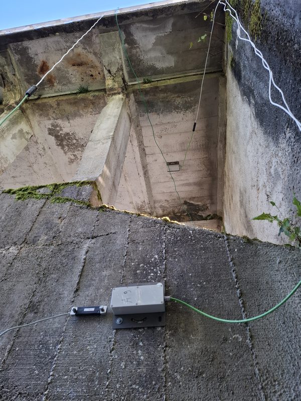 Instrumentation vibratoire installée sur un ouvrage maçonné, avec capteurs et système d’acquisition de données fixés à la structure.