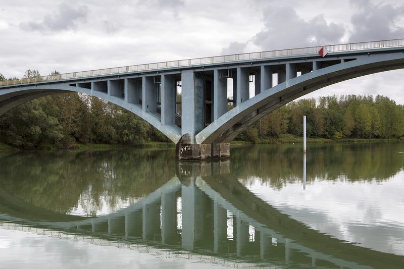 Pont en arc franchissant un cours d’eau, illustrant un ouvrage d’art en service.