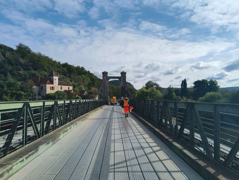 cajarc-bridge-structural-inspection Structural inspection on the Cajarc Bridge with a worker in high-visibility clothing and a technical vehicle on the deck.